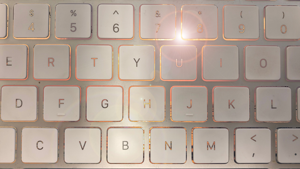 Computer keyboard with art and light flares leaking out between keys.